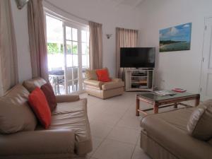 a living room with two couches and a television at Vida Mejor - East Pool in Saint James