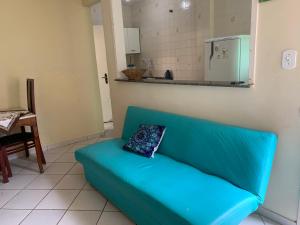 - un canapé bleu dans le salon avec un oreiller dans l'établissement Casa da Praia das Dunas, à Cabo Frio