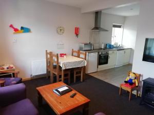 a living room with a table and a kitchen at The River House Self Catering Apartment in Dungloe