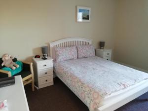 a bedroom with a bed and a chair with a teddy bear at The River House Self Catering Apartment in Dungloe