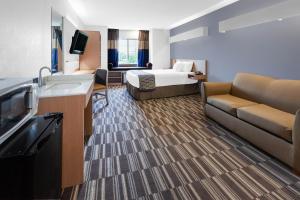 une chambre d'hôtel avec un lit et un canapé dans l'établissement Microtel Inn Suite by Wyndham BWI Airport, à Linthicum