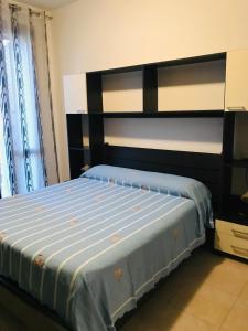 Schlafzimmer mit einem Bett mit blauer Decke in der Unterkunft Alghero Appartamento la Corbata in Alghero