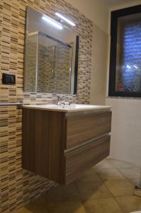 W łazience znajduje się umywalka i lustro. w obiekcie Casa vacanze da Anna w mieście Tortolì