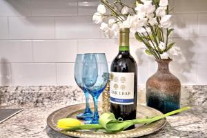 a bottle of wine and a glass and flowers on a counter at Relaxing, Comfortable, Private Bedroom in Atlanta