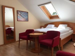 a bedroom with a bed and a table and chairs at Aurora Panzió in Bük