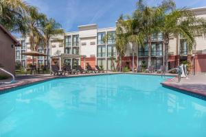 a large swimming pool in front of a building at Wyndham Visalia in Visalia