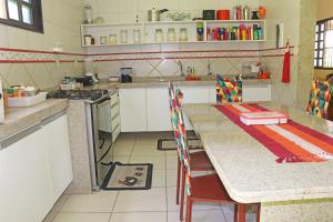 a kitchen with a table with chairs and a stove at Casa Verde in Porto De Galinhas