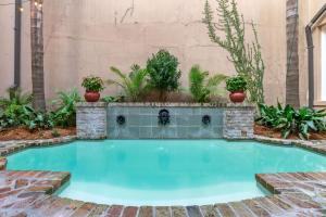 a swimming pool in a garden with plants at voco St James Hotel, an IHG hotel in New Orleans