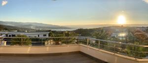 a view from the balcony of a house with the sunset at Résidence Les Jardins du Fort in Porticcio