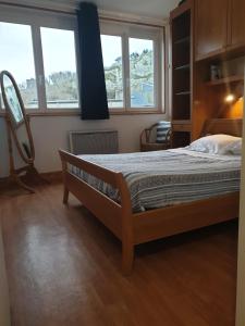 um quarto com uma cama e duas janelas em Goéland em Le Tréport