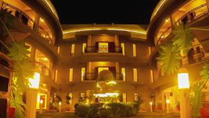 a large building with a courtyard at night at Hotel Lubumbashi in Lubumbashi