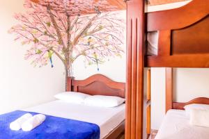 a bedroom with two bunk beds and a tree mural at Hospedaje La Masia Salento in Salento