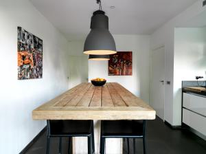 a wooden table in a kitchen with a black light fixture at B & B Waalre in Waalre