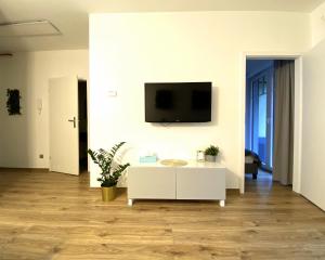ein Wohnzimmer mit einem weißen Tisch und einem TV an der Wand in der Unterkunft Apartamenty Polanica Zdrój in Polanica-Zdrój