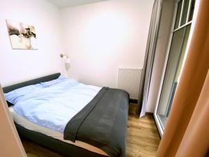 Bett in einem Zimmer mit Fenster in der Unterkunft Apartamenty Polanica Zdrój in Polanica-Zdrój