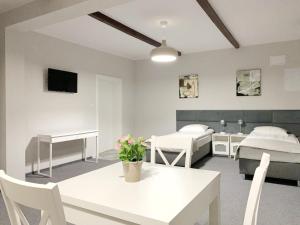 a room with two beds and a table with flowers on it at Apartamenty ZZ in Obryta