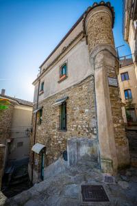 un vieux bâtiment en pierre avec une tour sur le côté dans l'établissement Il Fascino del Borgo, à Castellabate