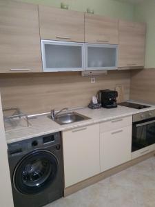 uma cozinha com um lavatório e uma máquina de lavar roupa em Private Apartment A12 in July Morning Seaside Resort em Kavarna