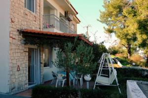 a yard with a swing and a house at Petra's House in Polychrono