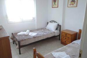 a small bedroom with a bed and a wooden dresser at Petra's House in Polychrono