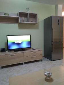 uma sala de estar com uma televisão de ecrã plano num centro de entretenimento em madeira em Private Apartment A12 in July Morning Seaside Resort em Kavarna
