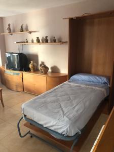 a bedroom with a bed and a tv in a room at Apartamento las Yucas - Aguilas in Águilas