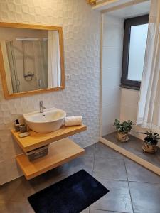 a bathroom with a sink and a mirror at Casa do António Júlio in São Roque do Pico