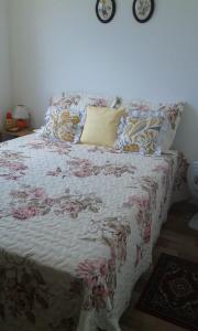 uma cama com um cobertor florido e almofadas em VOG Torres do Sul Ilhéus em Ilhéus