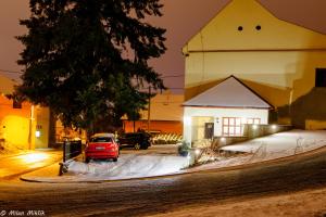 un coche aparcado en un aparcamiento al lado de un edificio en Restaurace a penzion pod hradem, en Zlín