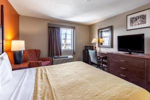 a hotel room with a bed and a desk and a television at Americas Best Value Inn - Temple in Temple