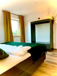 a bedroom with a large green bed with a window at Airport & Messe Apartments in Hannover