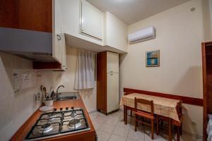 a small kitchen with a stove and a table at Il Fascino del Borgo 2 in Castellabate