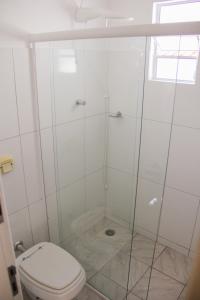 een witte badkamer met een toilet en een douche bij Juveve Loft Apartment in Curitiba