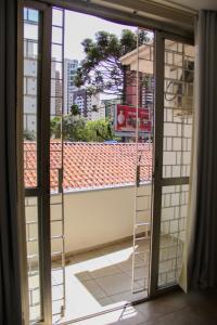 een open raam met uitzicht op een gebouw bij Juveve Loft Apartment in Curitiba