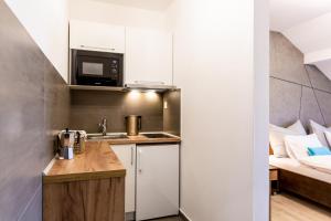 a small kitchen with a sink and a bed at Apartmán Dagmar in Bešeňová