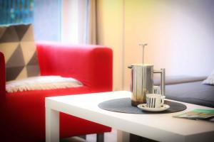 - une cafetière sur une table à côté d'une chaise rouge dans l'établissement City Centre - Parking - Great Location - 4 Beds, à Belfast