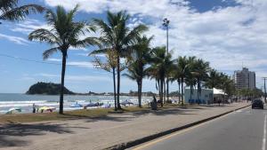 eine Straße mit Palmen am Strand in der Unterkunft Pousada Residencial Paineiras in Guaratuba