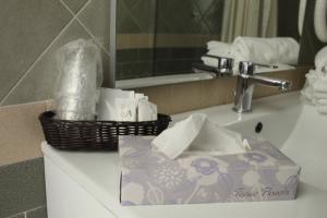 a bathroom sink with a basket of toiletries on it at La Dea dell'Abbondanza in Agropoli