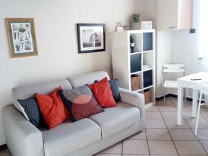 a living room with a gray couch with colorful pillows at Appartamento Luisa in Parma