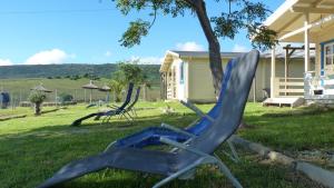 une chaise de pelouse bleue dans l'herbe à côté d'une maison dans l'établissement Maryvacas Rural, à La Zarzuela