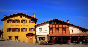 a large yellow building next to a brown and white building at Perlakua Saka in Deba