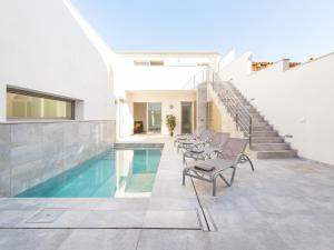 a house with a swimming pool with chairs and stairs at Villa margalida in Sa Pobla
