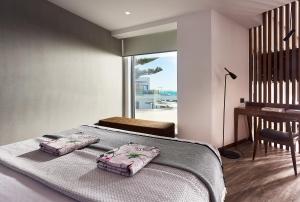 a hotel room with a bed and a chair at Dyo Suites in Rethymno Town