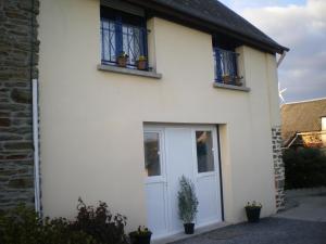a white house with a white door and two windows at Chambres Les Salles in Beauvoir