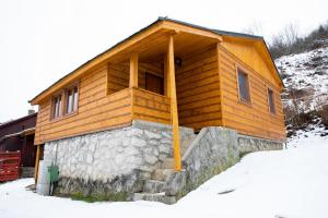 een houten huis met sneeuw op de grond bij Chata Pohoda pri Jánošíku in Terchová