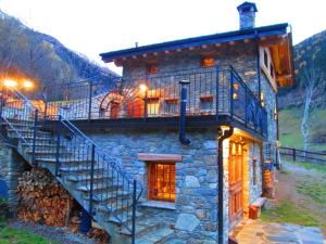 a stone house with a staircase on the side of it at Chalet Cuore Selvatico in Monno