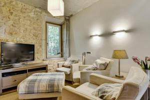 een woonkamer met witte meubels en een flatscreen-tv bij Designer Haus in Armissan