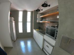 a small kitchen with white cabinets and a refrigerator at Departamento en Nueva Cordoba, 2 dormitorios in Cordoba