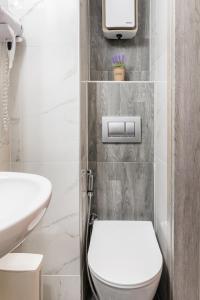 Un baño blanco con inodoro y lavabo. en Cityscape, en Tesalónica