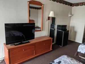 a flat screen tv on a dresser in a hotel room at Key West Inn - Montgomery South in Montgomery